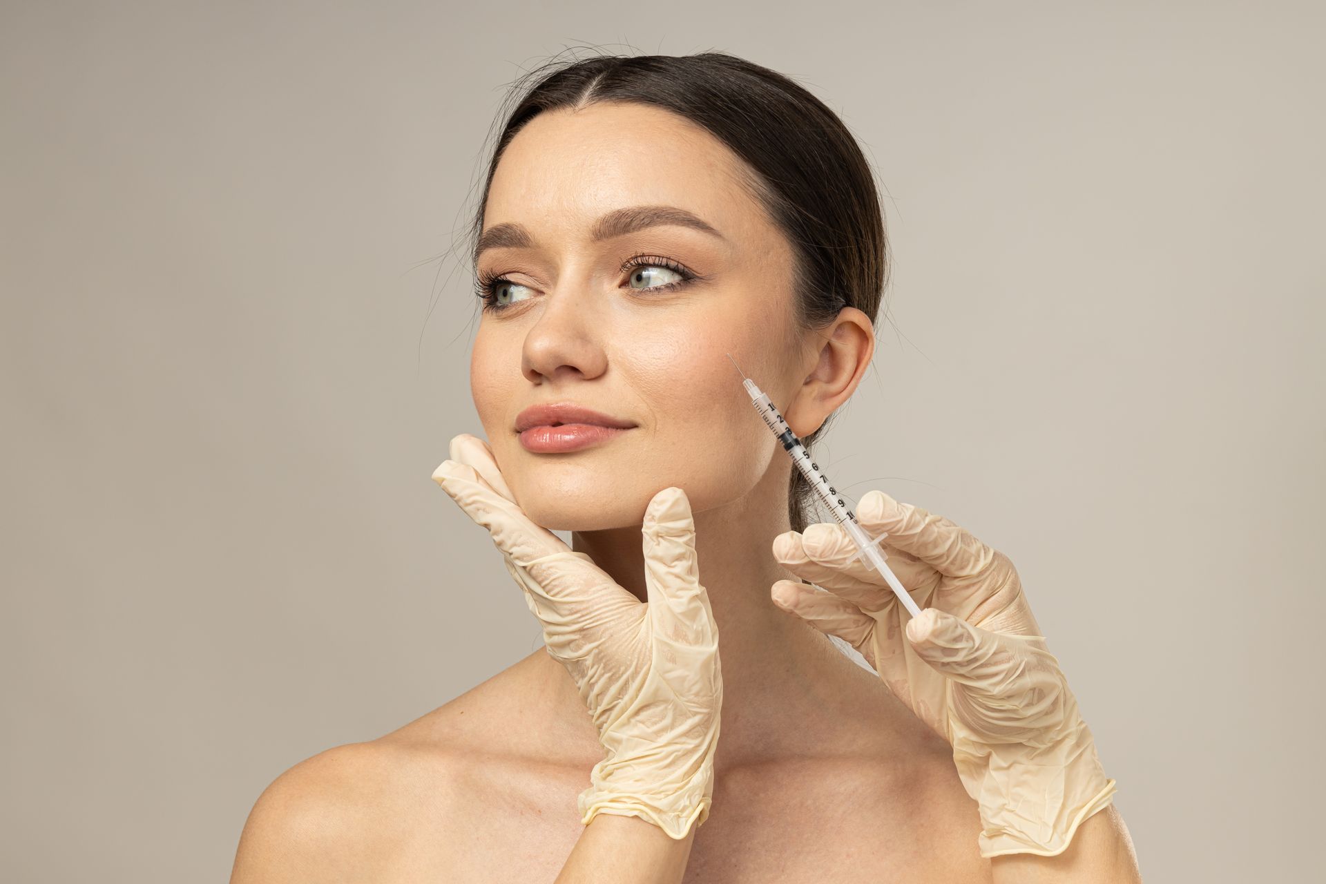 A woman is getting a botox injection in her face.