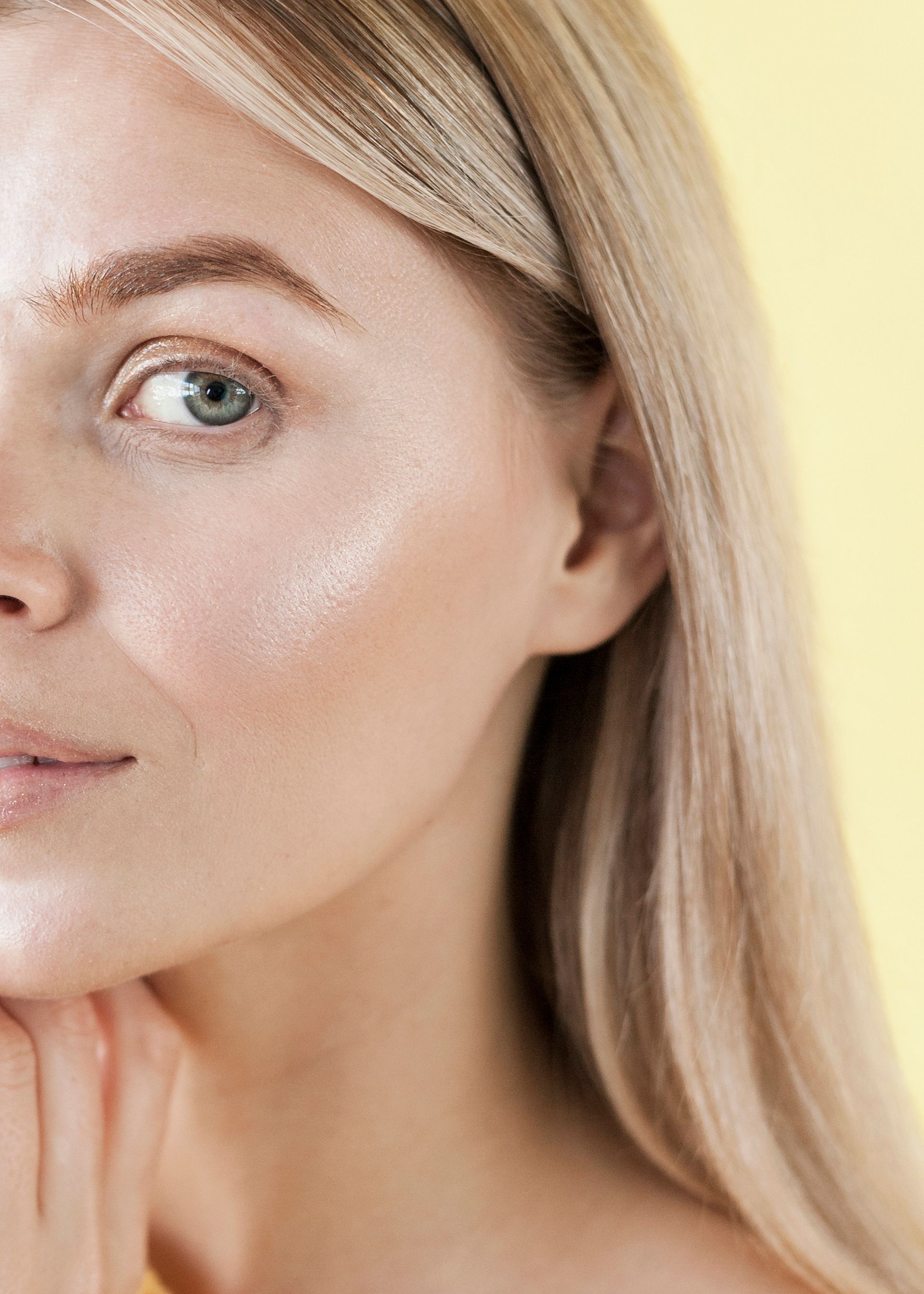 a close up of a woman 's face with a yellow background