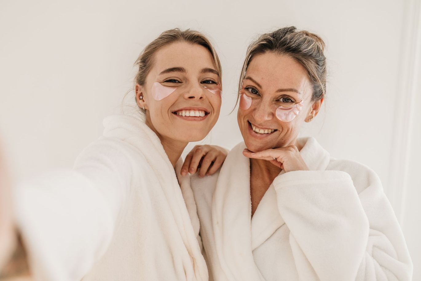 two women wearing eye patches smile for the camera