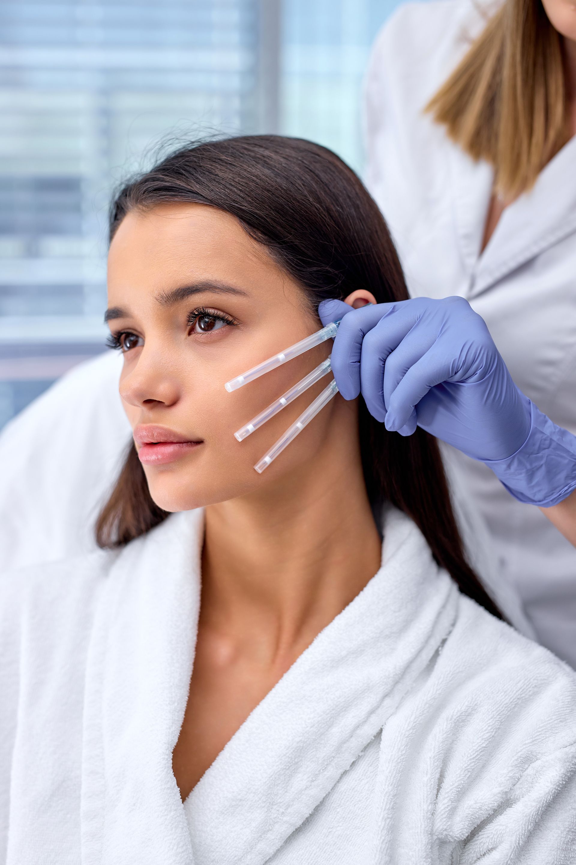 A woman is getting a botox injection in her face.