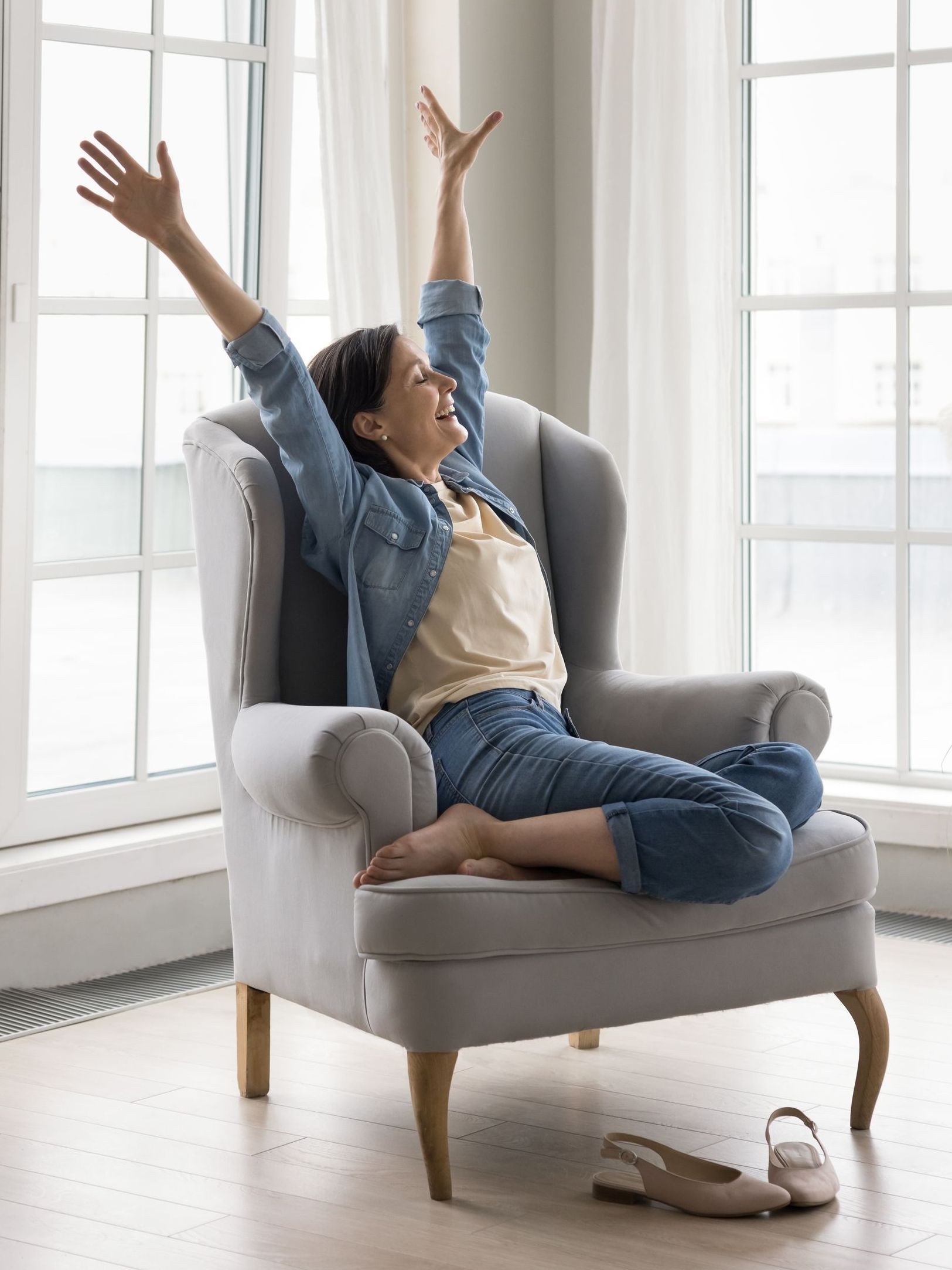 a woman sits in a chair with her arms outstretched