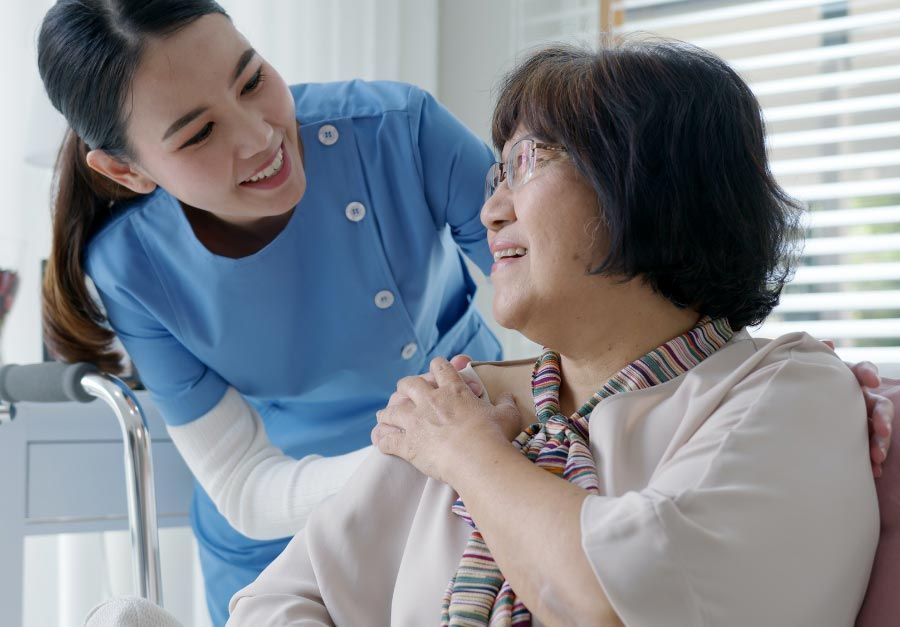 Happy elderly woman with a friendly caregiver, enjoying personalized senior care at home.