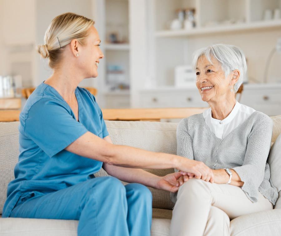 Compassionate caregiver supporting an elderly woman, providing quality in-home care services for seniors.