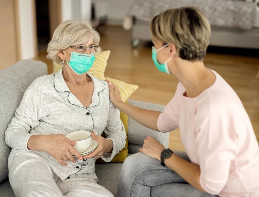 Professional caregiver assisting a senior woman with safe and hygienic home care services.