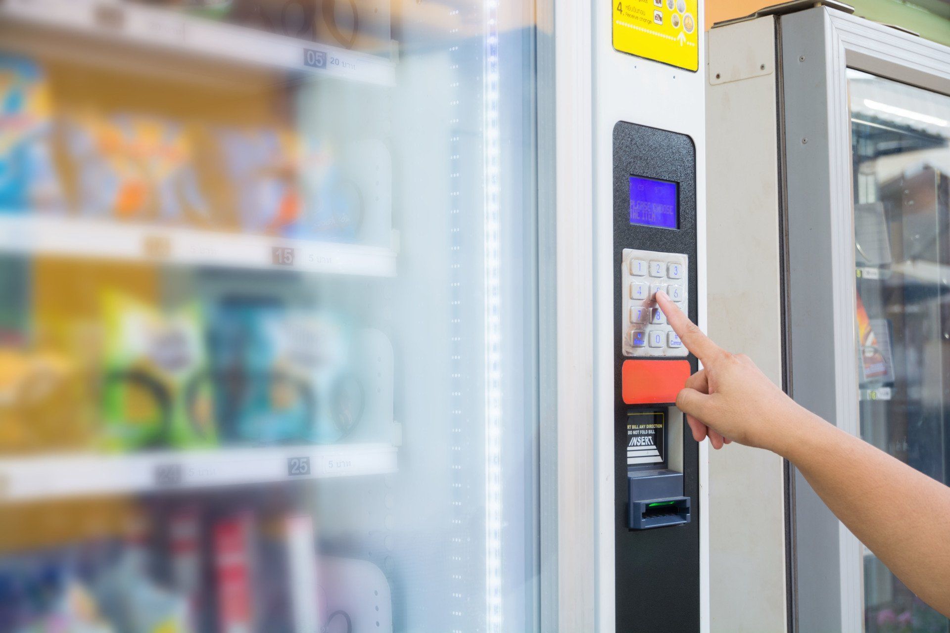 A person is using a vending machine in a store.