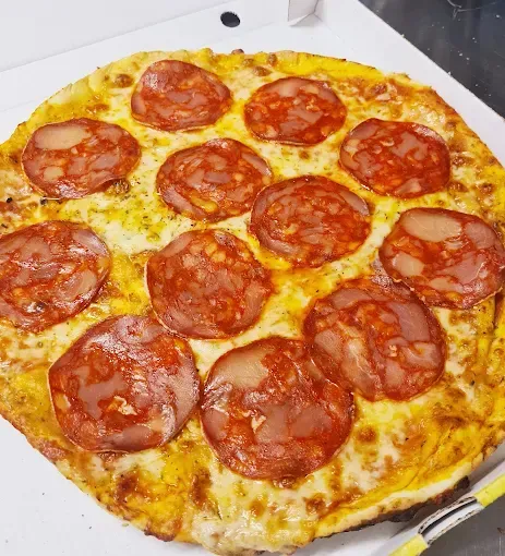Pizza au pepperoni dans une boîte ouverte, gros plan.