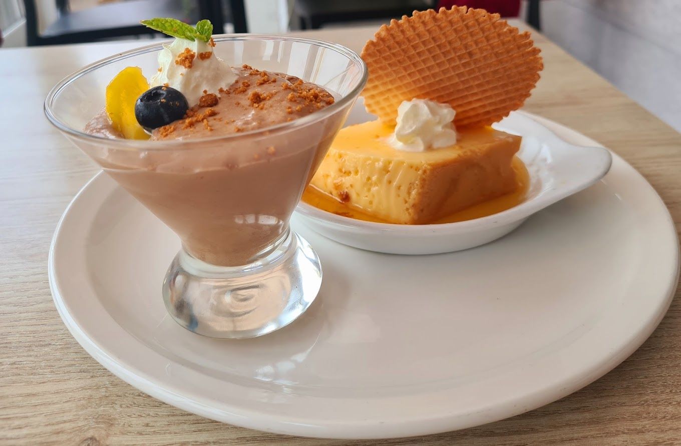Assiette de desserts : mousse au chocolat, crème anglaise avec biscuit, crème fouettée, myrtille et mangue.
