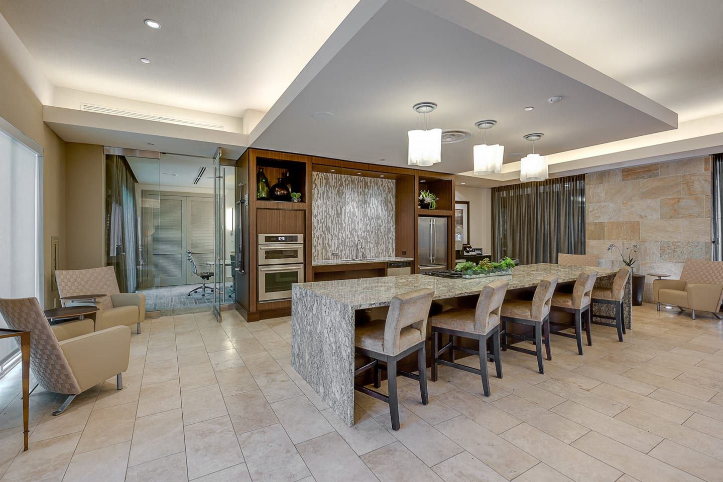 a large kitchen with a long counter and chairs