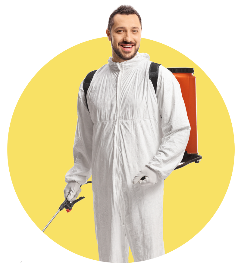 A man in a white coverall is holding a sprayer.