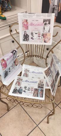 Un'edicola dorata con giornali, su un pavimento piastrellato.