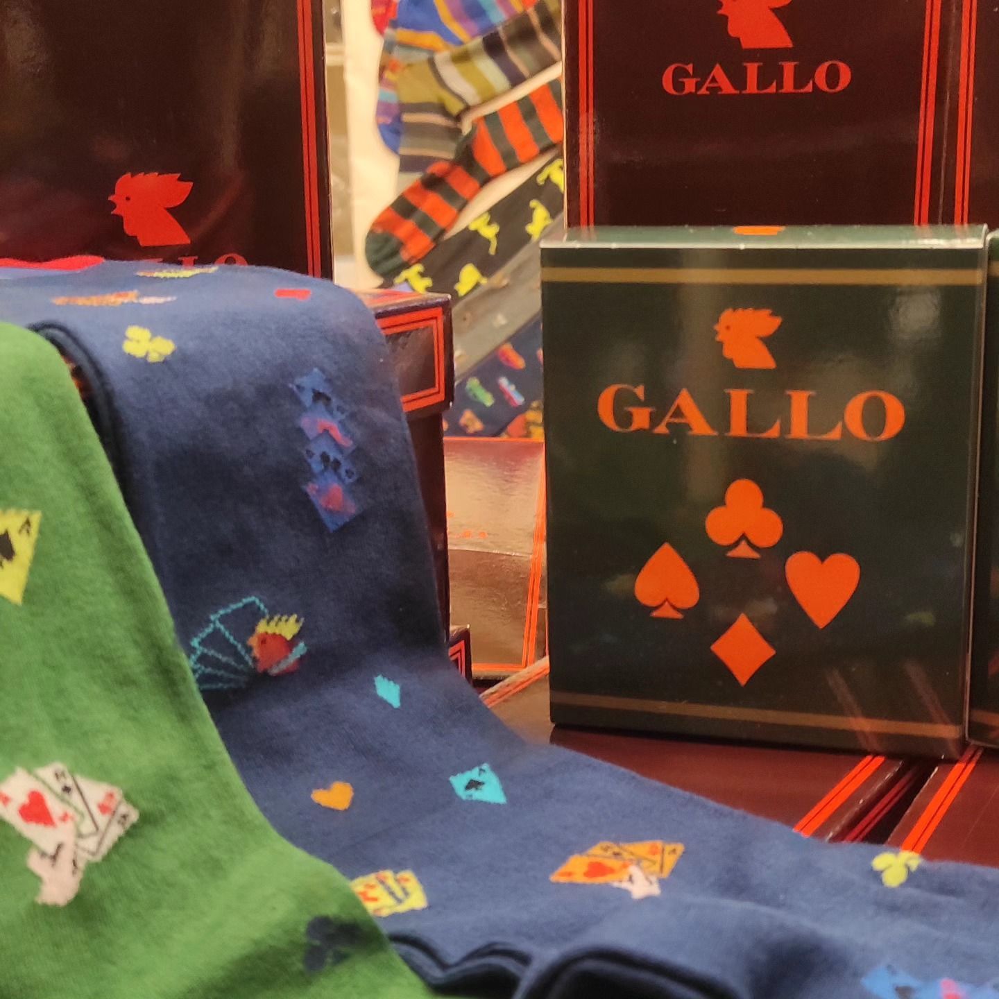 Calzini con disegni di carte da gioco e scatole Gallo in un negozio.