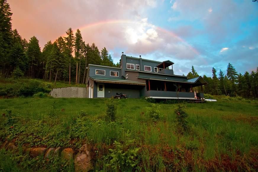 a house on a hill with the sun behind it.