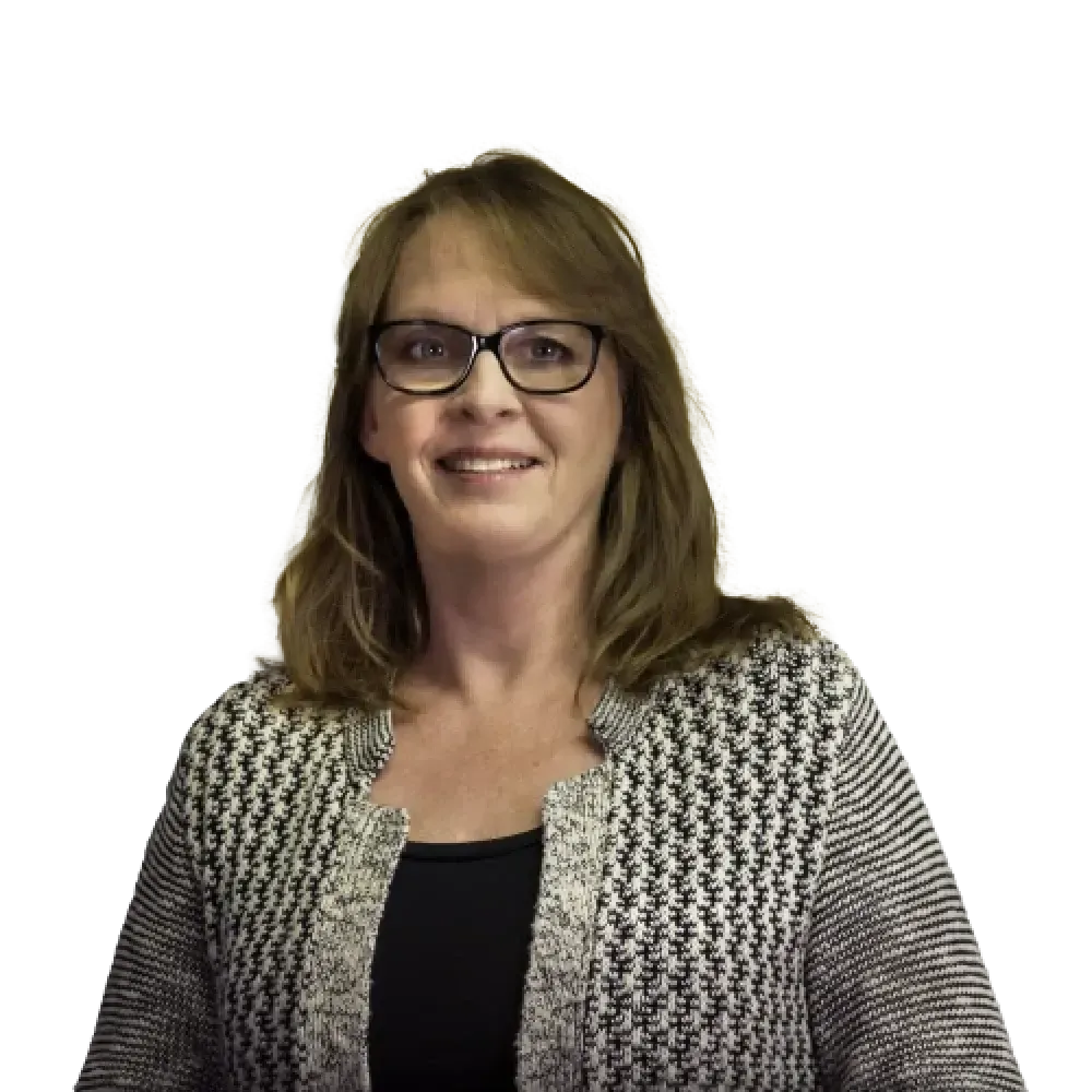 A person with shoulder-length brown hair and glasses, wearing a black and white textured cardigan over a black top.