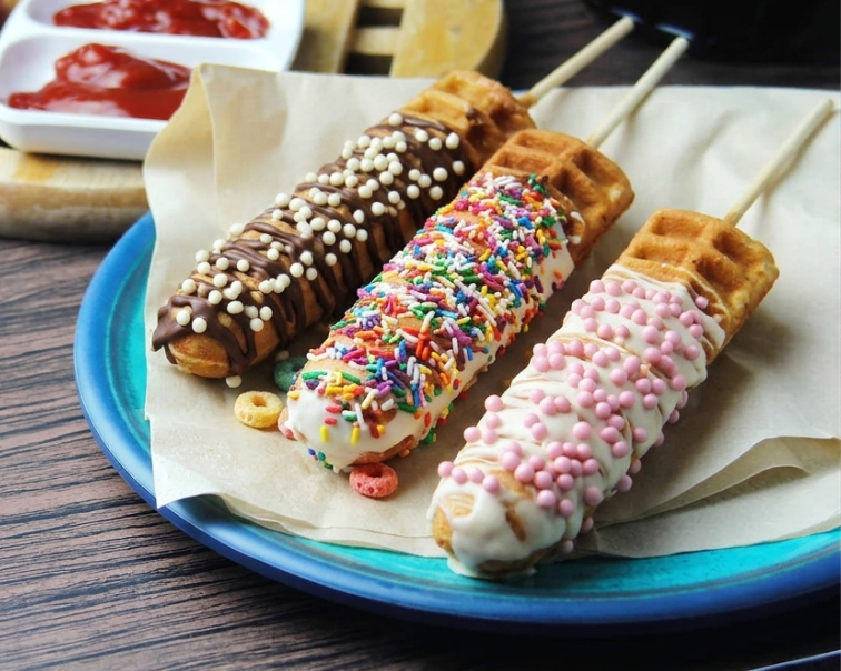 Due waffle dorati impilati su uno sfondo bianco