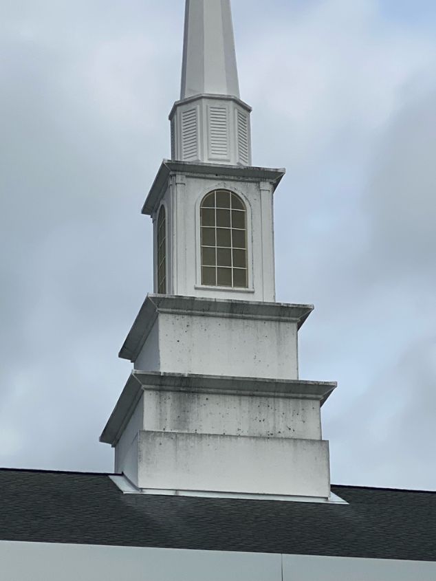 White church steeple against a cloudy sky.