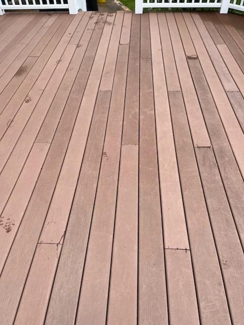 Wooden deck with reddish-brown planks, leading to a white railing.