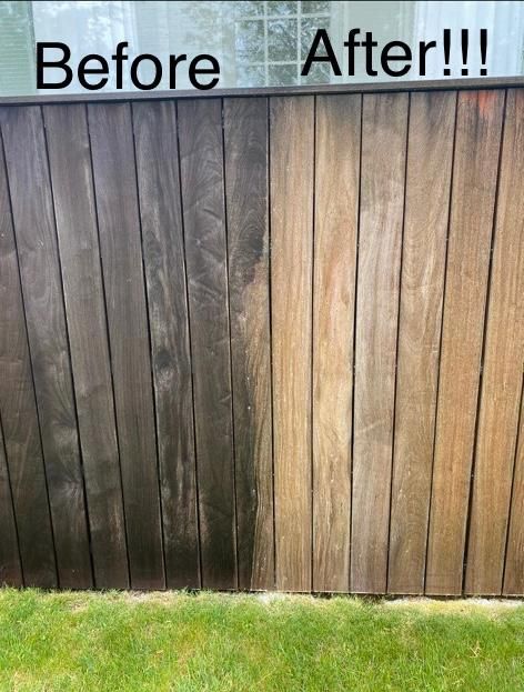 Wooden fence, half cleaned, showing before/after comparison. Dark, dirty left side, lighter, clean right side.
