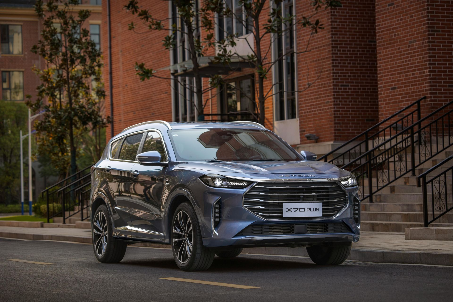 Blue SUV parked on a city street in front of a brick building.
