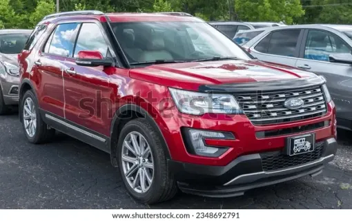 Blue SUV parked on a city street in front of a brick building.