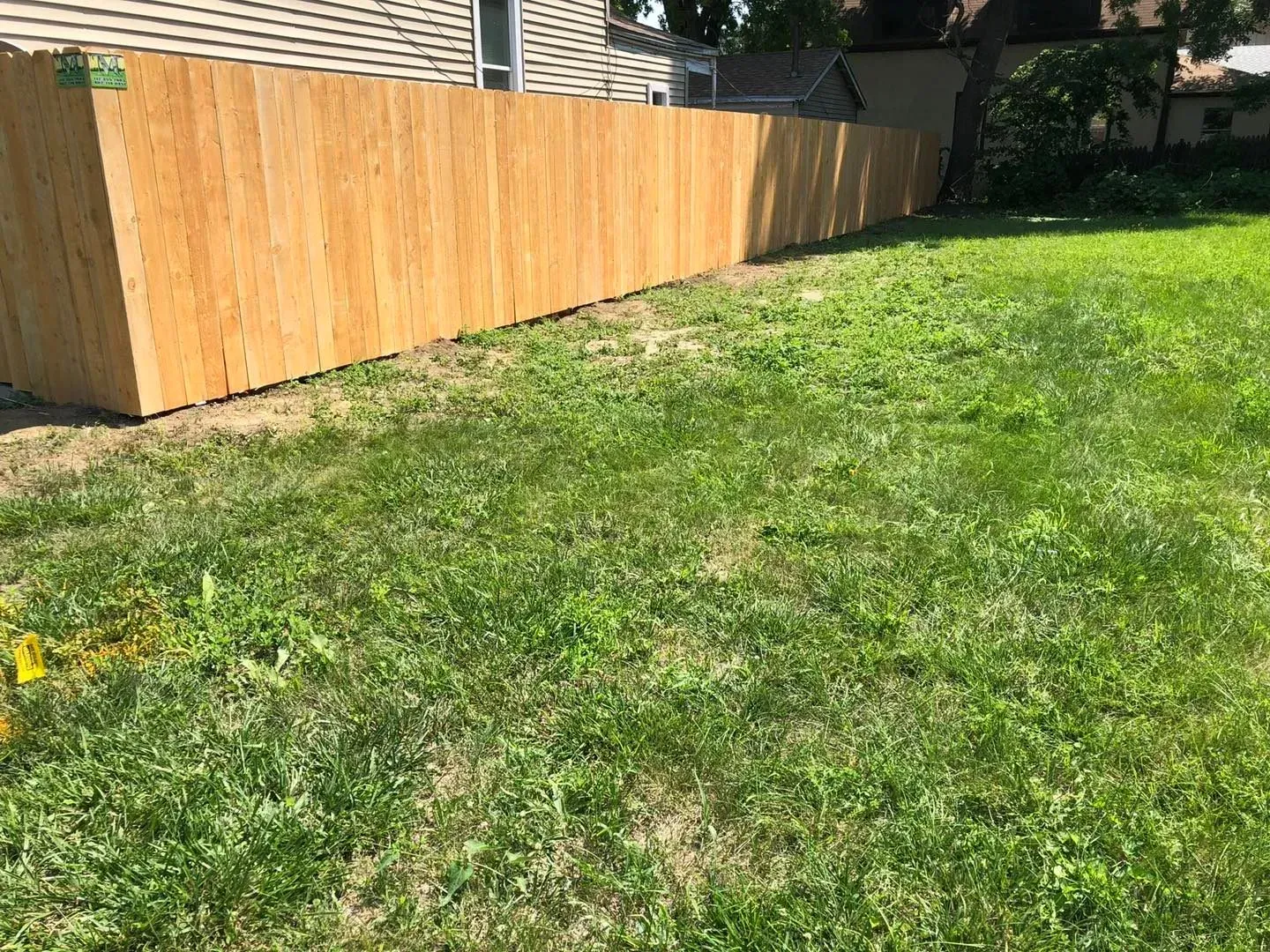 Wooden fence in a grassy yard.