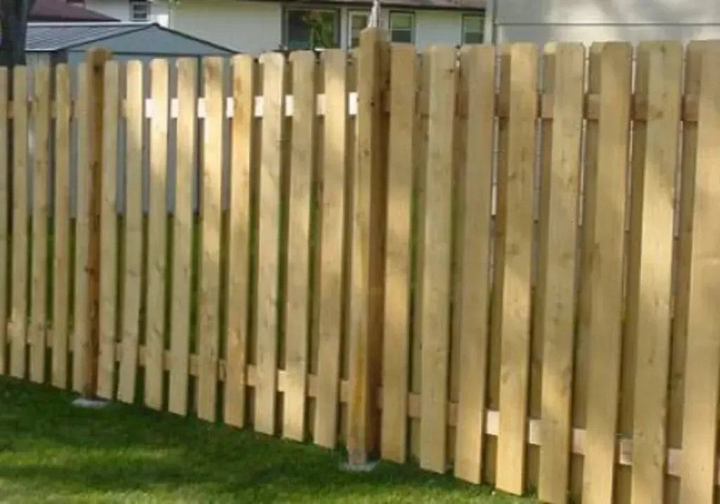 Wooden picket fence in a grassy yard.
