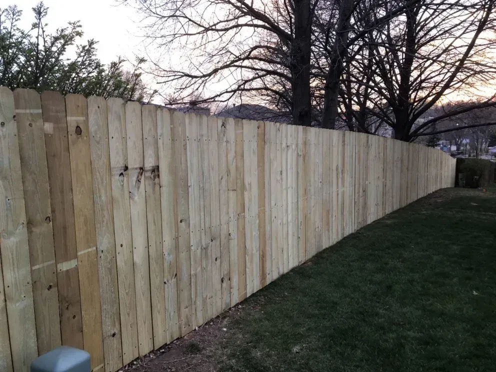 Wooden privacy fence in a grassy yard.