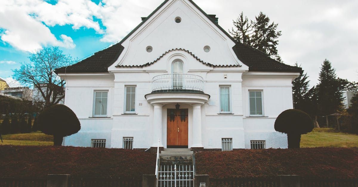 A large white house with stairs leading up to the front door