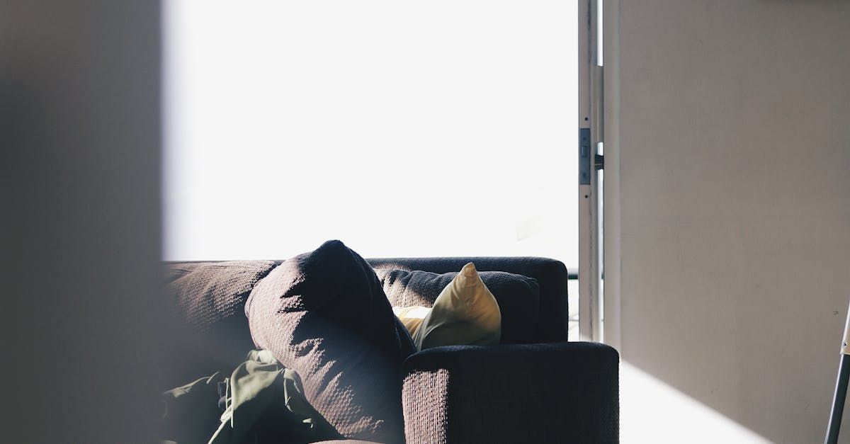 A couch is sitting in a living room next to a window.