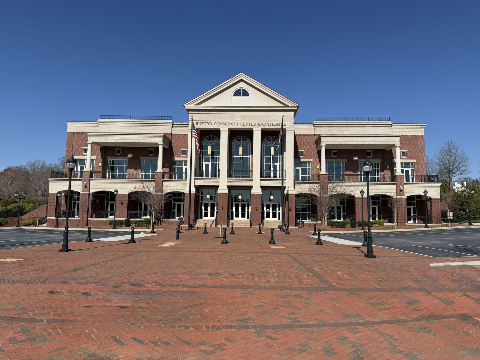 Brick building with columns and a red brick plaza.