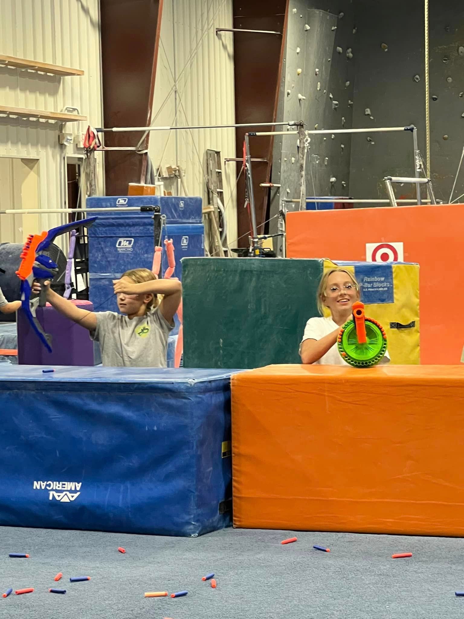 A boy and a girl are playing with toys in a gym.