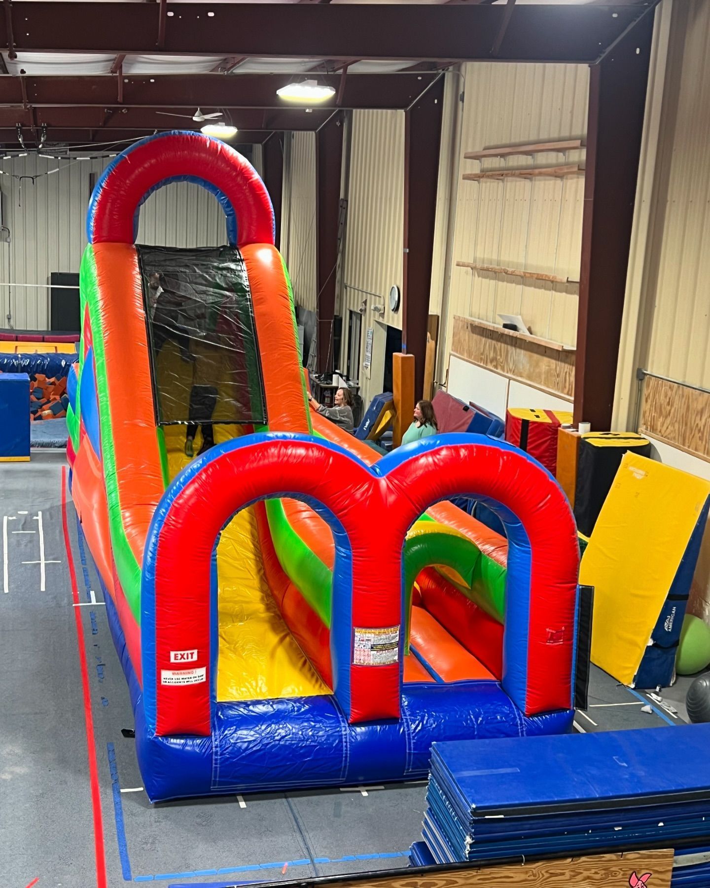 A colorful inflatable obstacle course in a gym