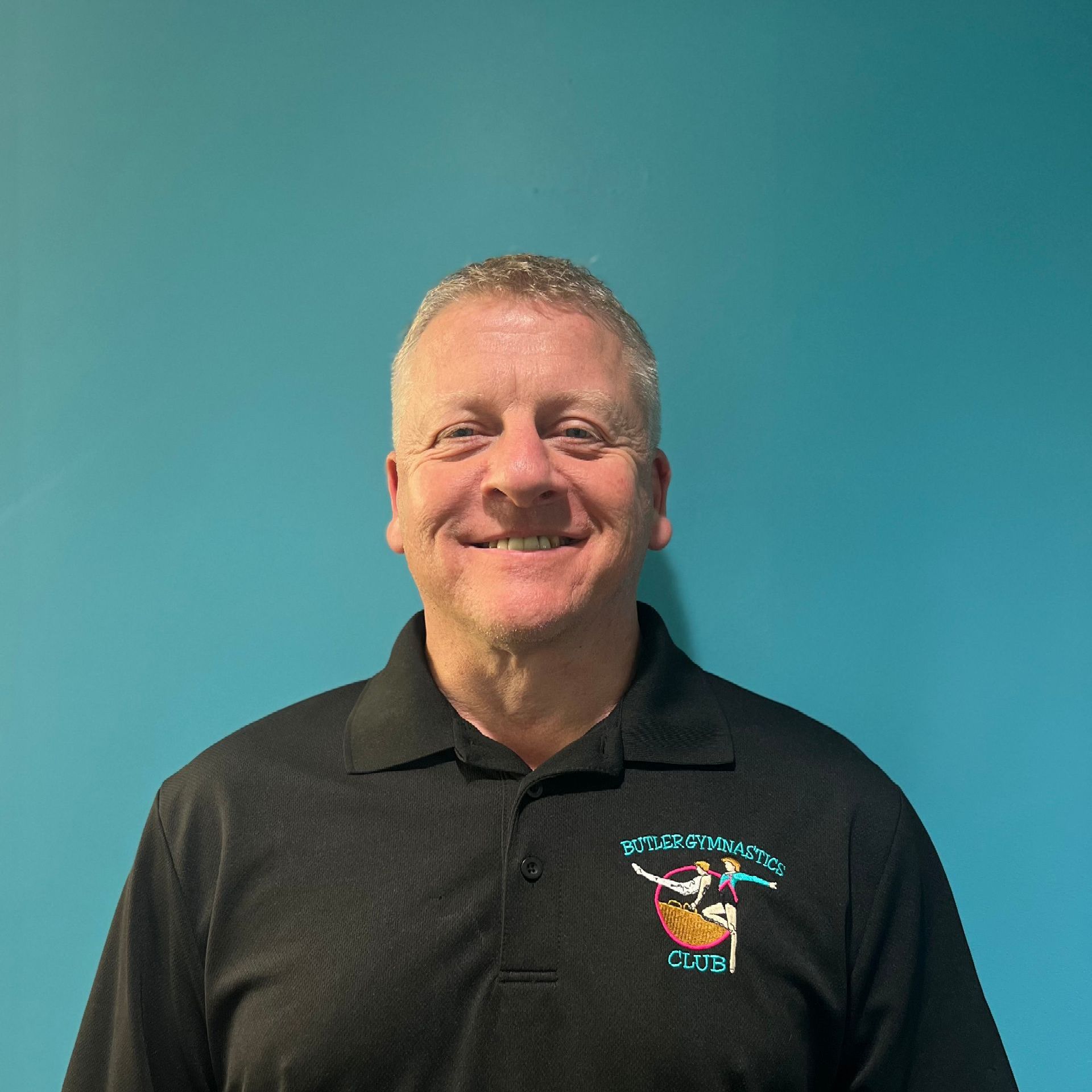 A man wearing a black shirt with the word coach on it