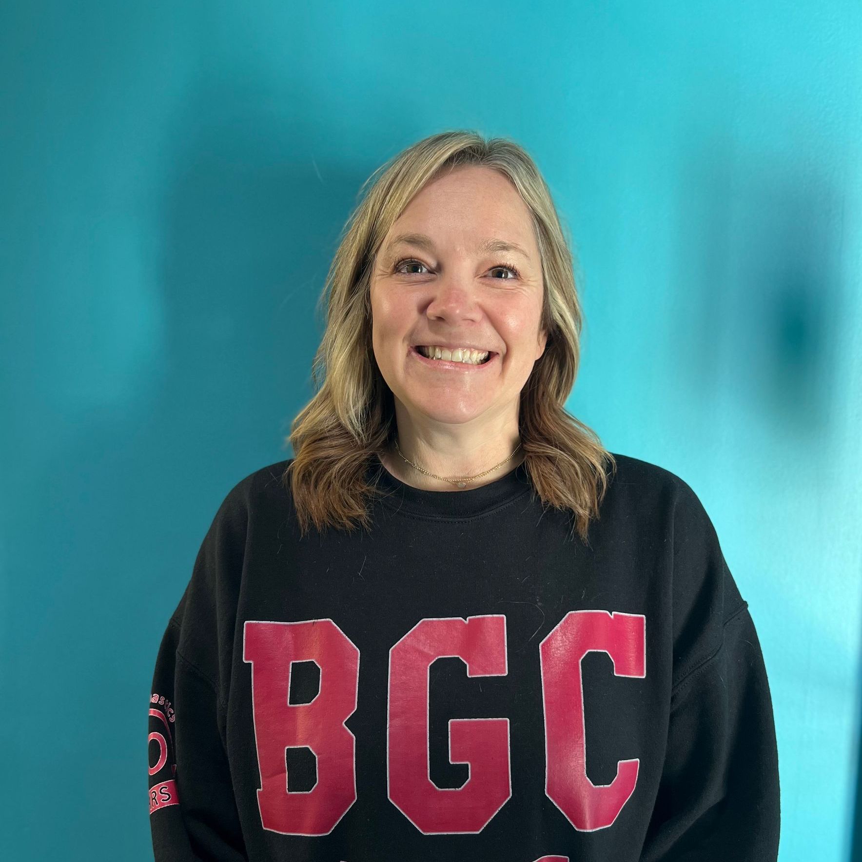 A woman wearing a black sweater with the word bgc on it