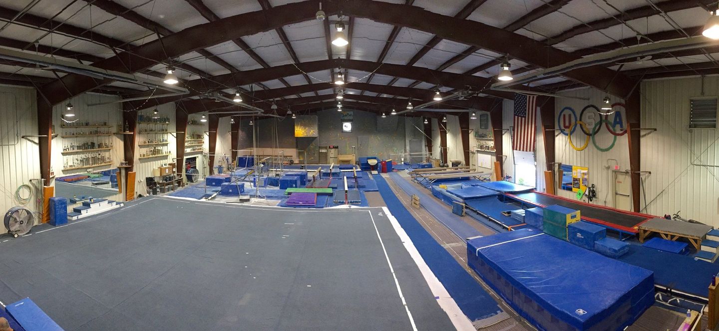 A large gym filled with lots of equipment and a trampoline.