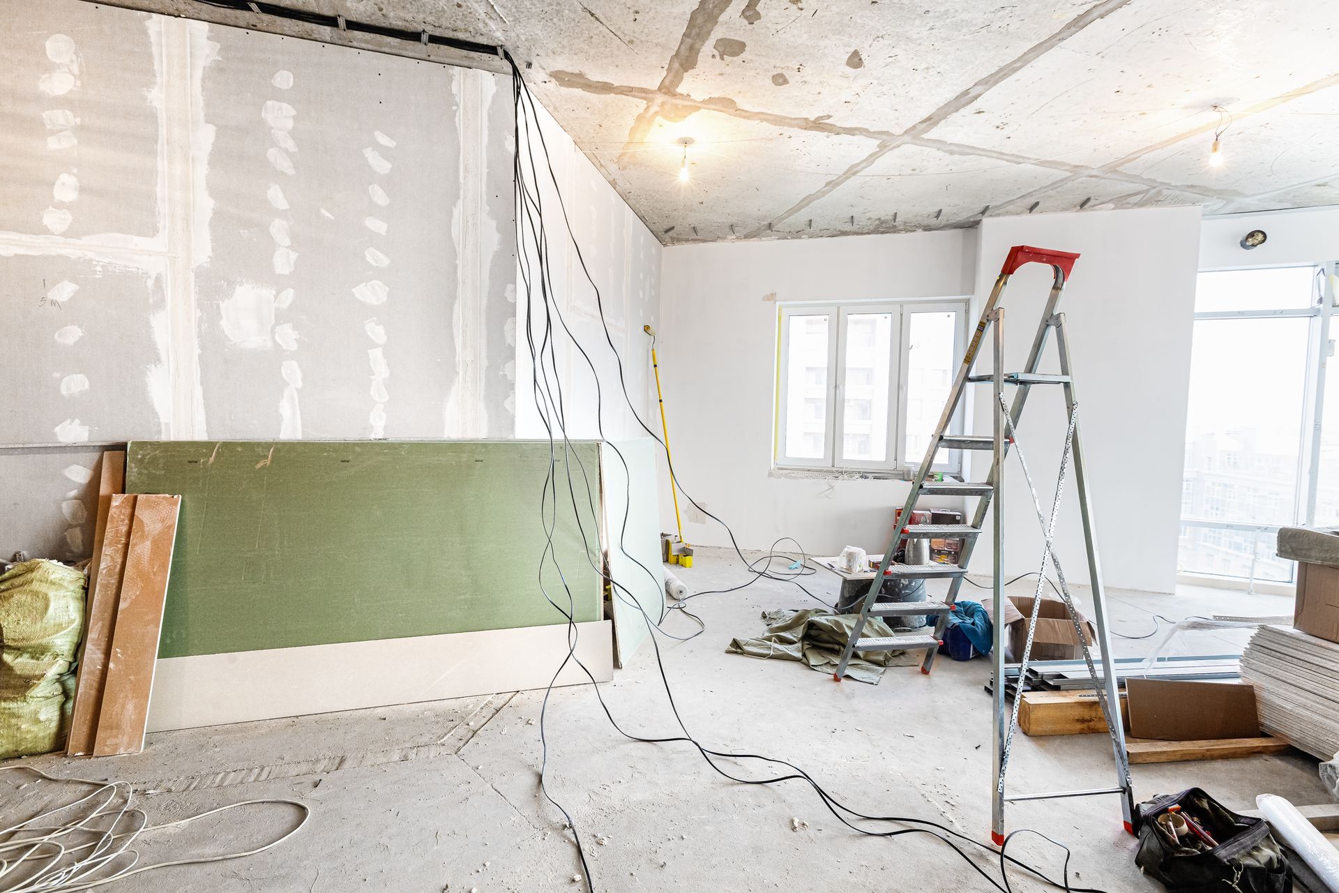 A room under construction with a ladder in the middle of it.