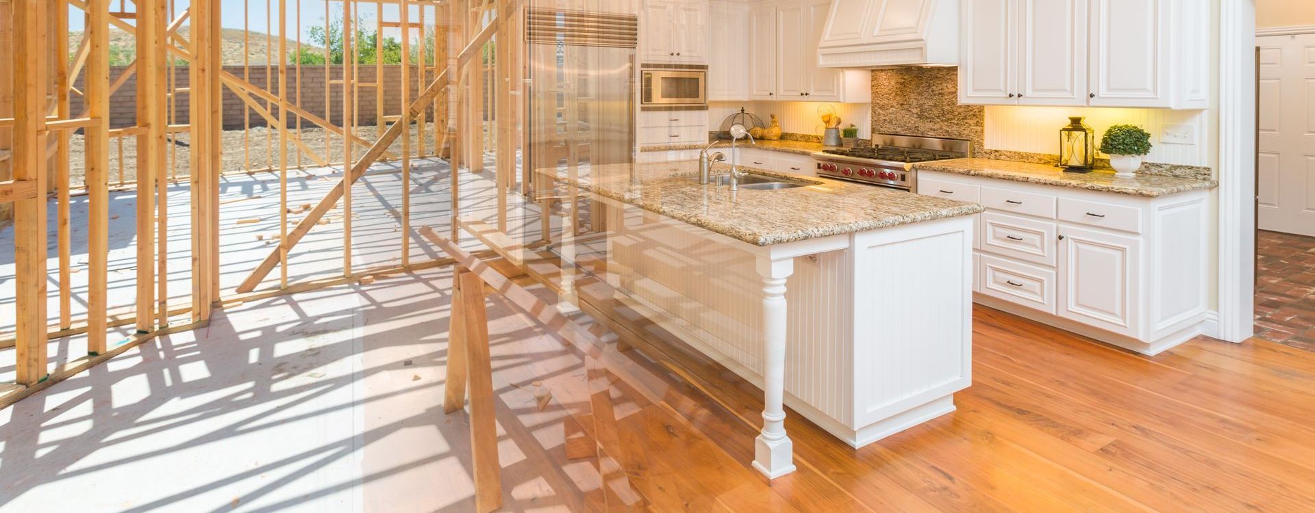 A kitchen in a house under construction with white cabinets and granite counter tops.