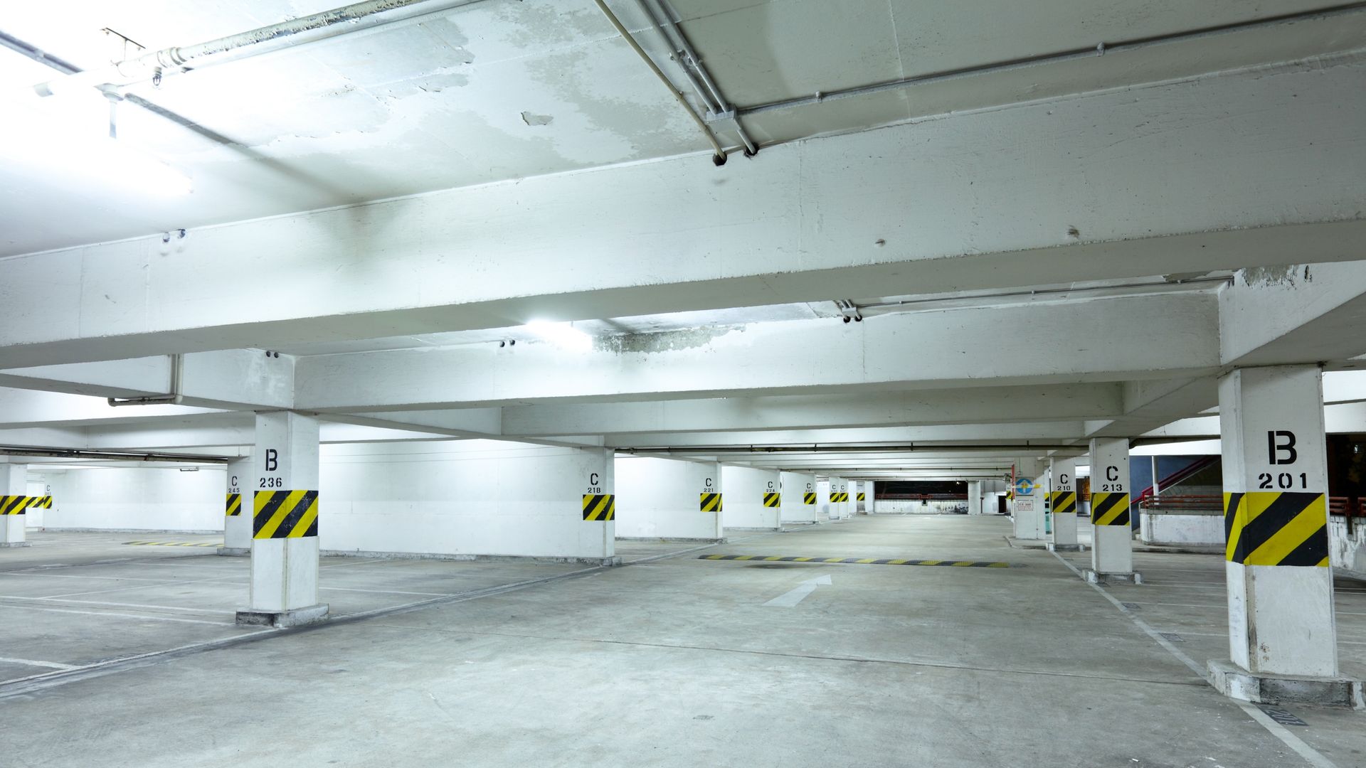 Two street lights are hanging from the side of a building.