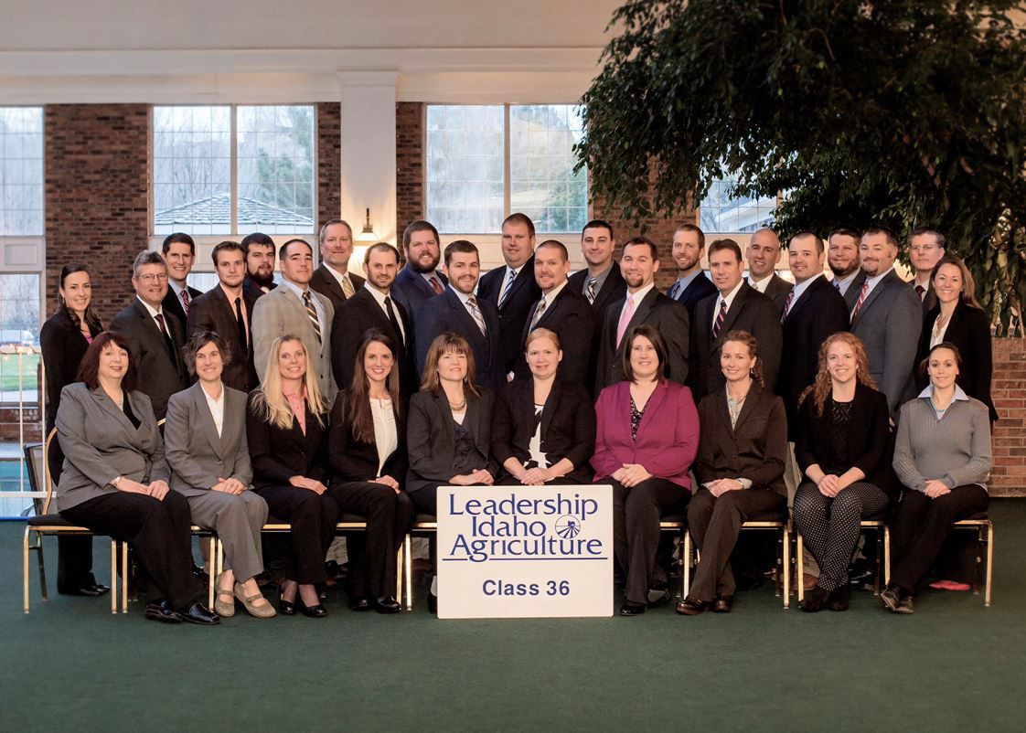 A group of professionals in business attire poses for a photo at a Leadership Idaho Agriculture class event.