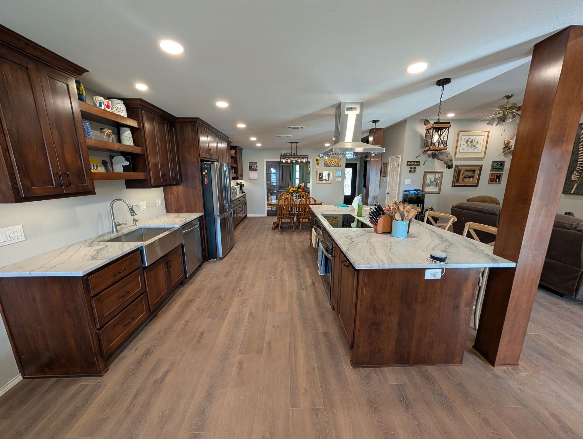 Kitchen with dark wood cabinets, island, and stainless steel appliances.