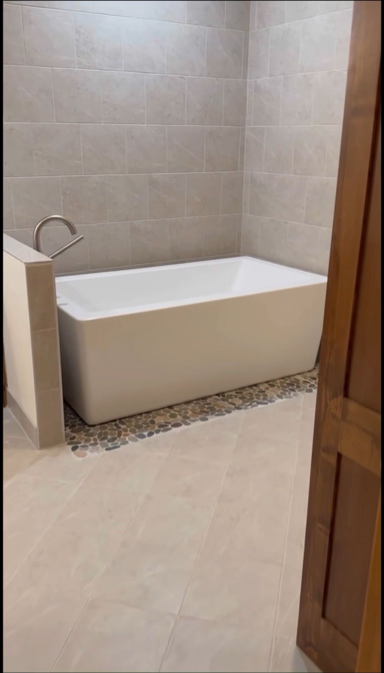 Built-in white bookcase with shelves and cabinets, brown countertop, set in a recess in a room with wood flooring.