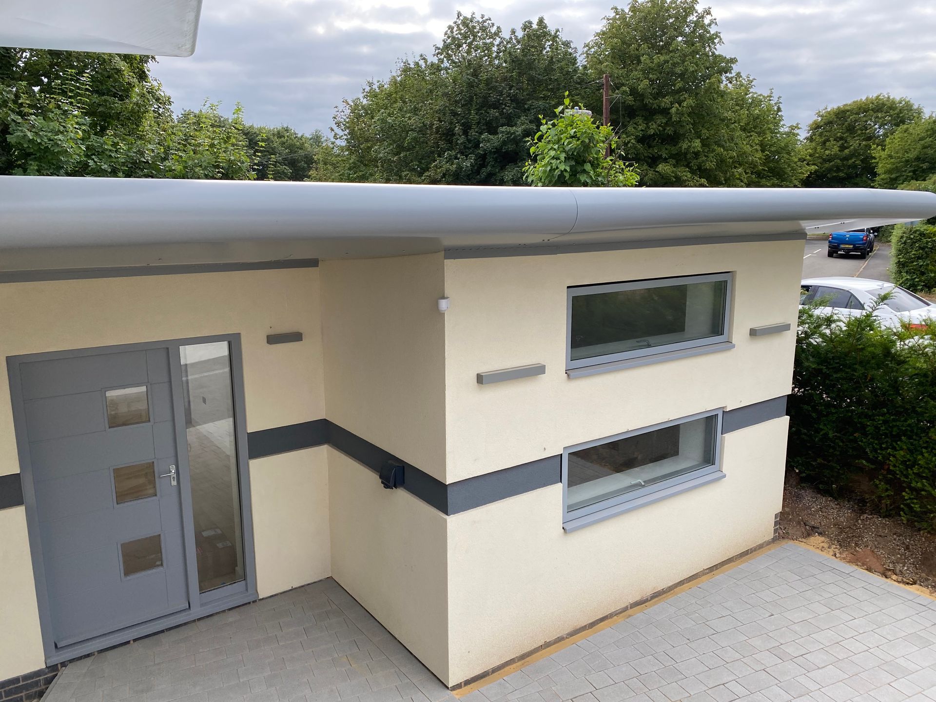 A small white building with a gray door and windows.
