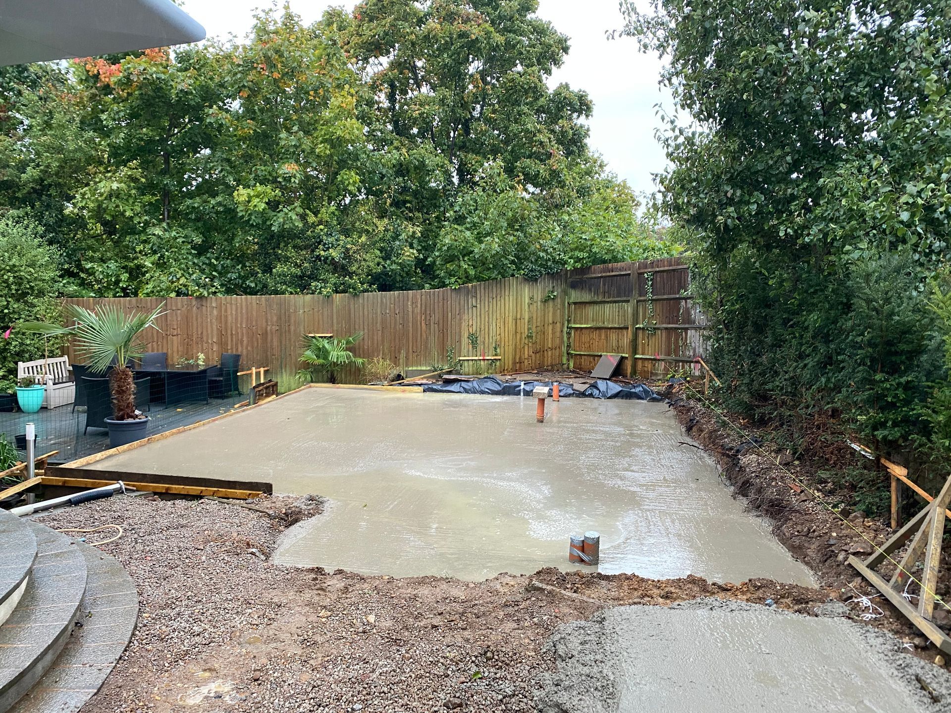 A concrete base is being built in a backyard.