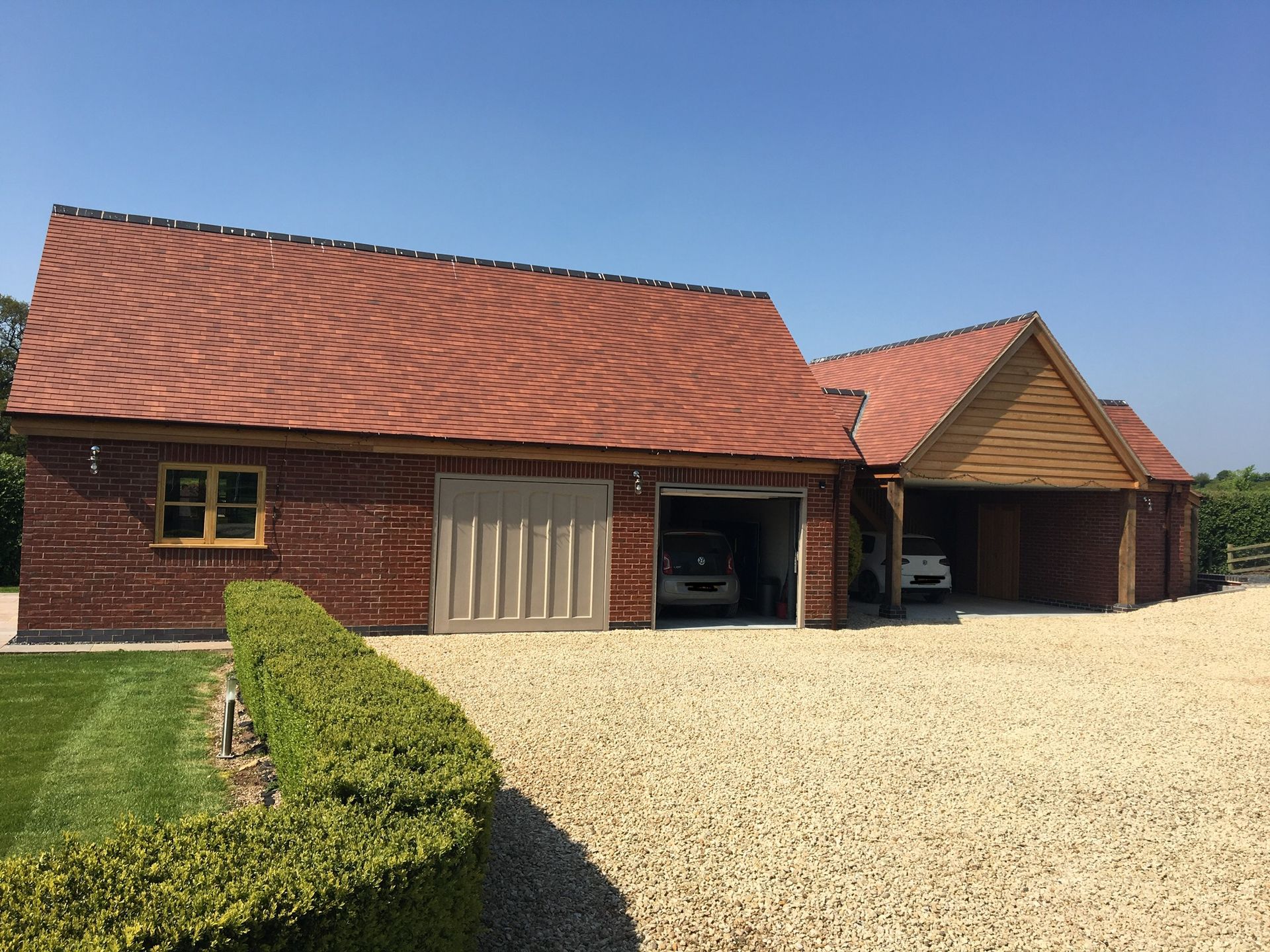 A house with a garage and two cars parked in it.