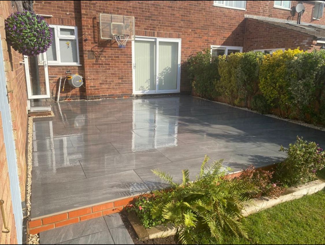 There is a patio in the backyard of a house.