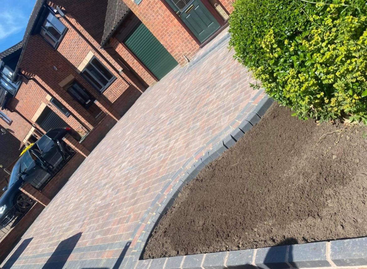 A brick driveway in front of a brick house