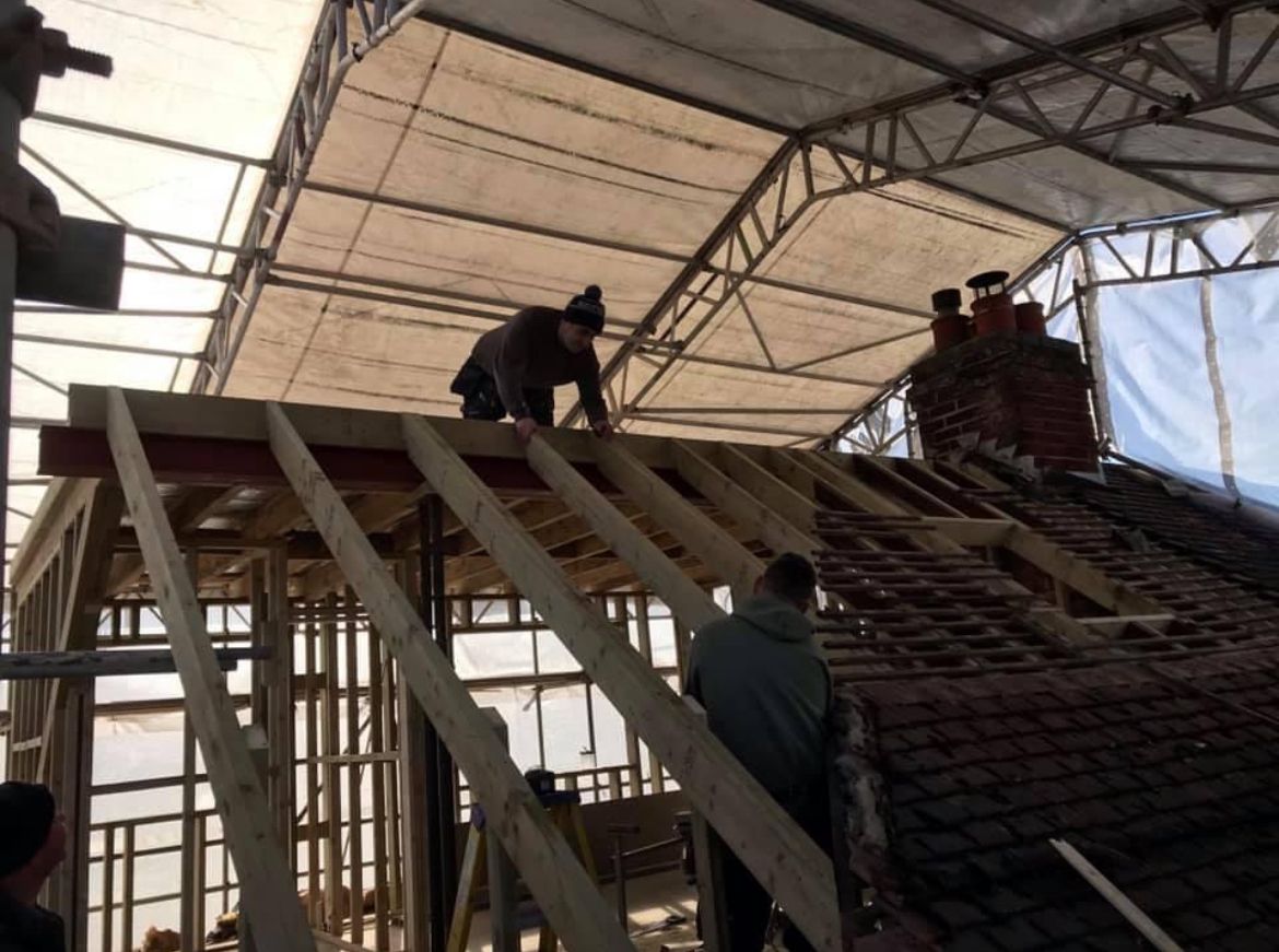 A group of men are working on the roof of a building.