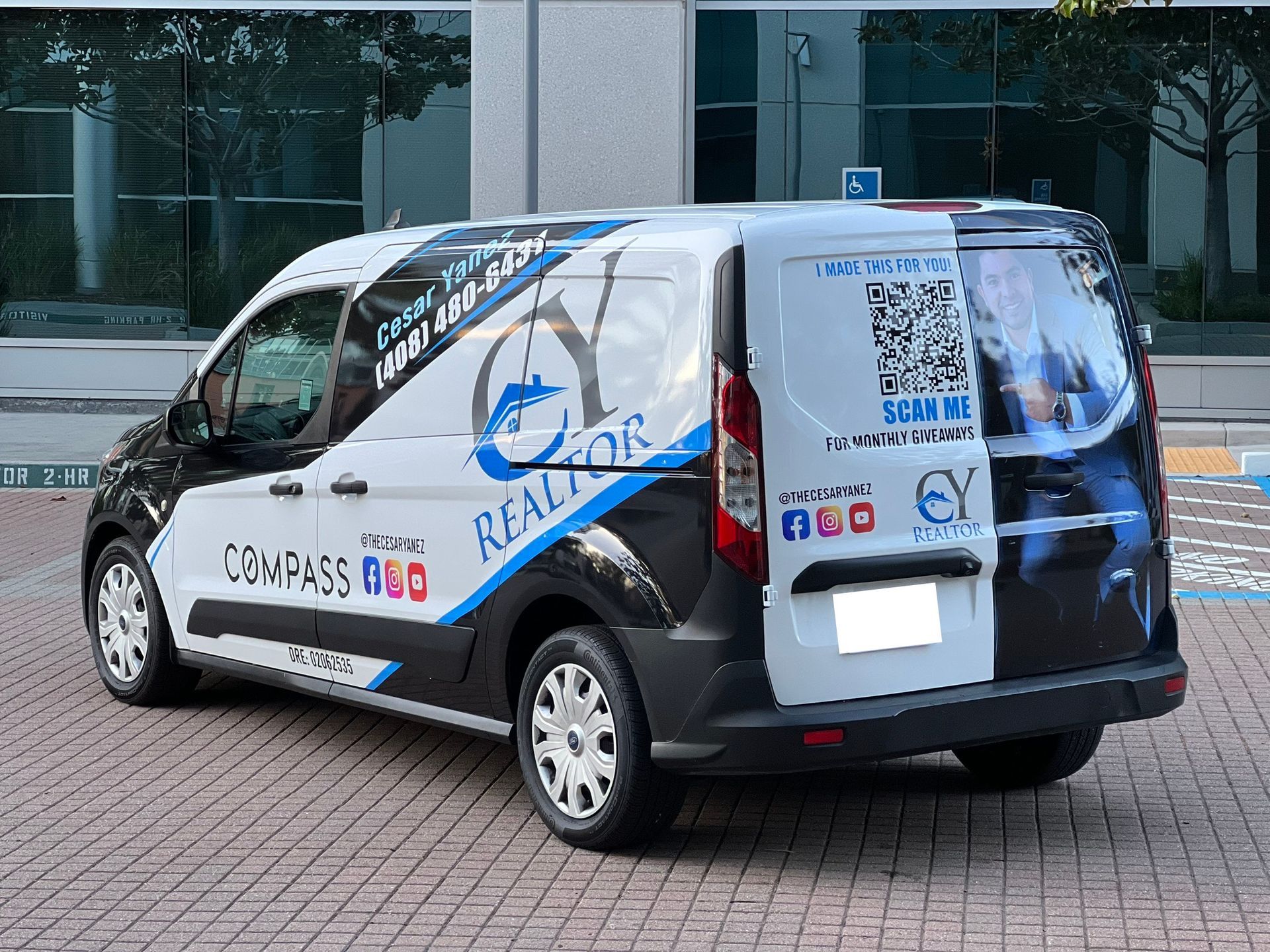 A black and white van is parked in front of a building.