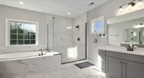 Mampara de ducha instalada en un baño de mármol blanco en la provincia de Castellón