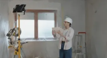 Mujer con un casco de seguridad coordinando la instalaciones de las ventanas de pvc de una casa en Castellón
