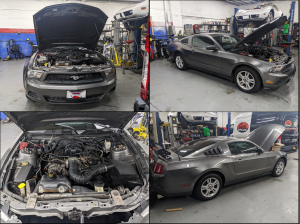 A ford mustang is being worked on in a garage.